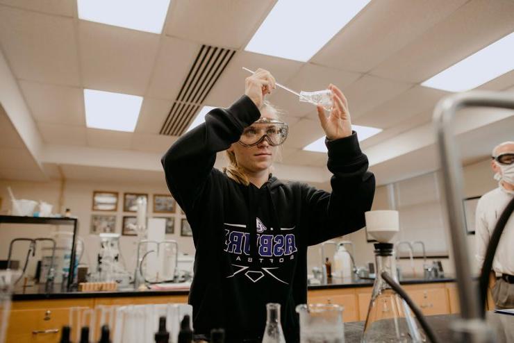 一位立博体育登录的本科生在科学实验室里使用烧杯